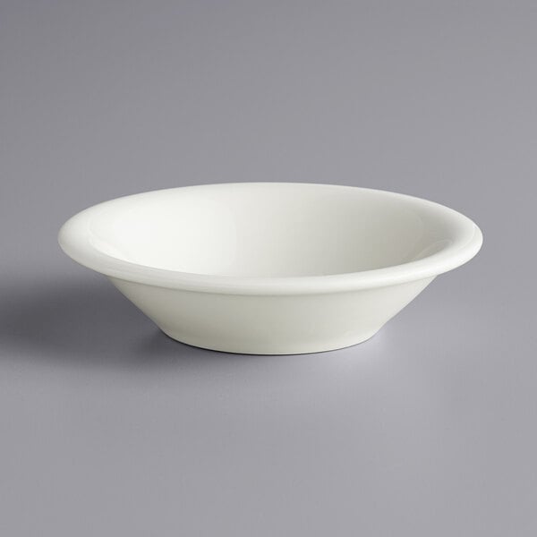 A close up of a Tuxton eggshell white china fruit bowl.