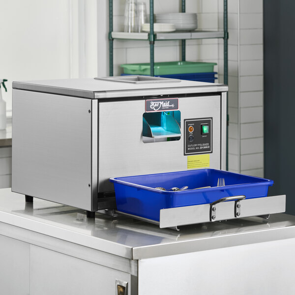 A stainless steel Bar Maid CP-3000 cutlery dryer and polisher machine with a blue tray for utensils.