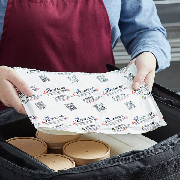 A woman holding a package of Vesture Microcore hot or cold packs.