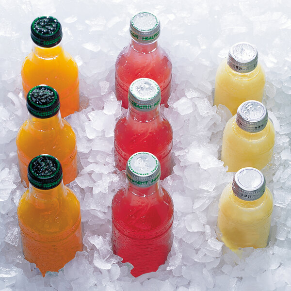 A group of bottles of yellow, orange, and red liquids in ice with a Manitowoc RFF1300W water cooled ice machine.