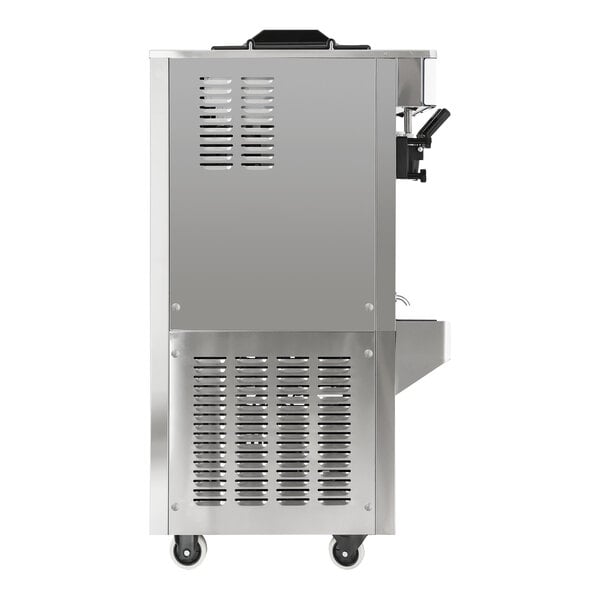 A stainless steel floor model soft serve ice cream machine with ventilation panels, wheels, and visible dispensers.