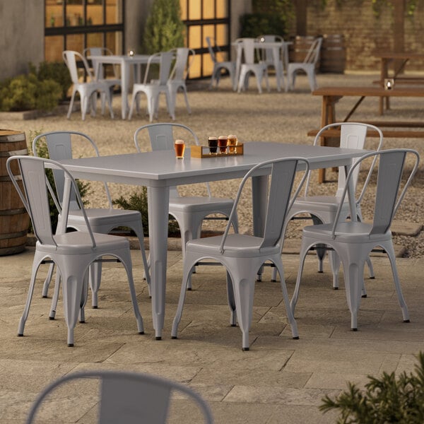 A Lancaster Table & Seating outdoor table and chairs on a patio.