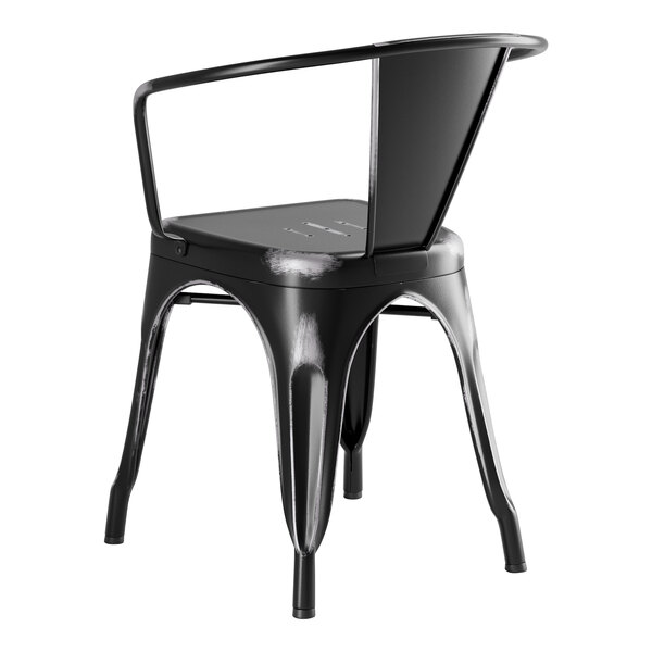 A Lancaster Table & Seating black metal chair with armrests and a backrest on a black metal table on an outdoor patio.
