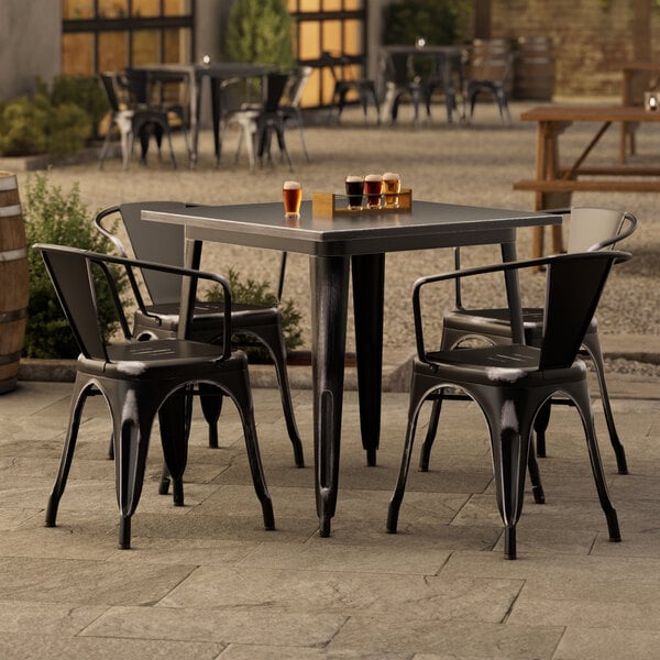 A Lancaster Table & Seating outdoor table and chairs on a patio.