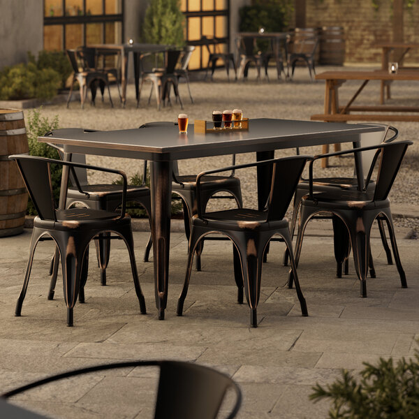 A Lancaster Table & Seating outdoor table with chairs on a patio.