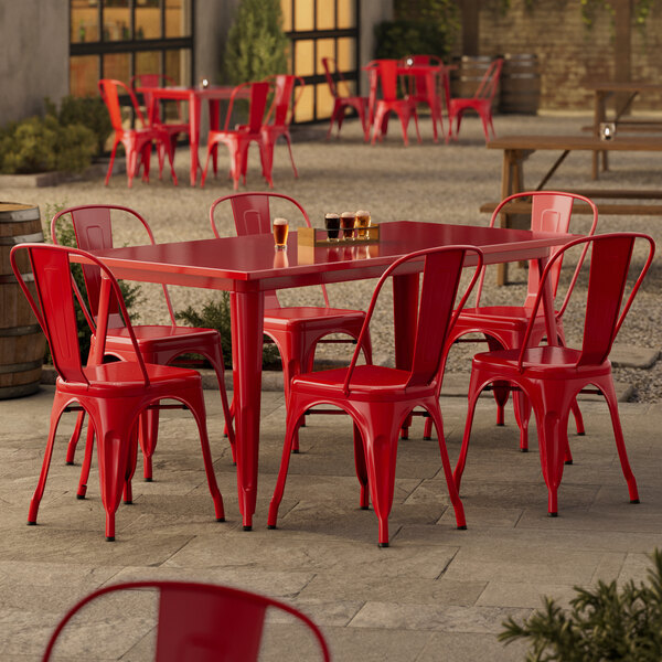 A Lancaster Table & Seating Ruby Red outdoor table with chairs on a patio.