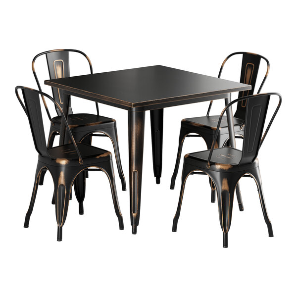 A Lancaster Table & Seating distressed copper table with black metal chairs.