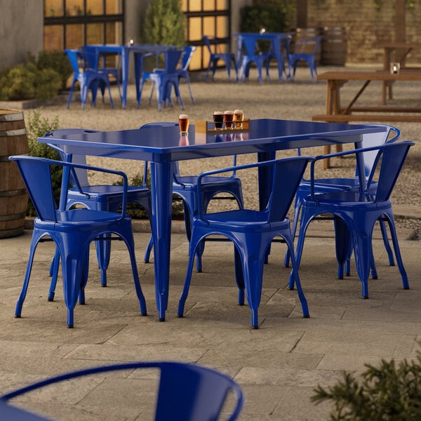 A blue table and chairs on a stone patio.