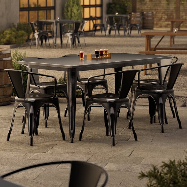 A Lancaster Table & Seating outdoor patio table with 6 black chairs.