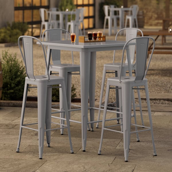 A Lancaster Table & Seating outdoor bar table with 4 chairs.