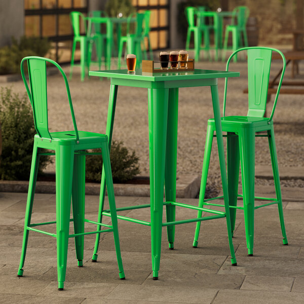 A Lancaster Table & Seating jade green outdoor bar table with chairs.