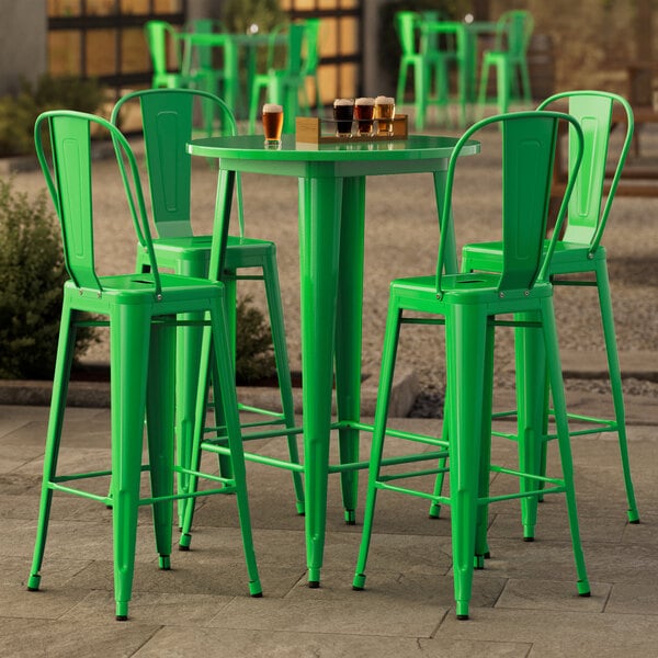 A Lancaster Table & Seating bar height outdoor table in jade green with four green barstools.