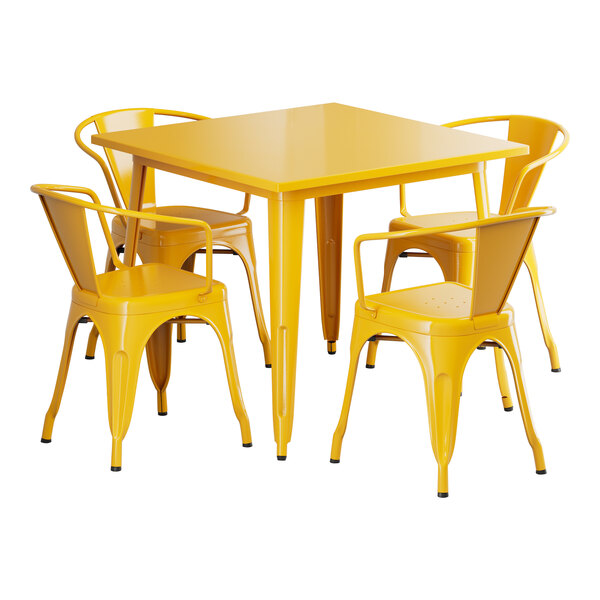 A Lancaster Table & Seating citrine yellow metal table and chairs set on a table outdoors.