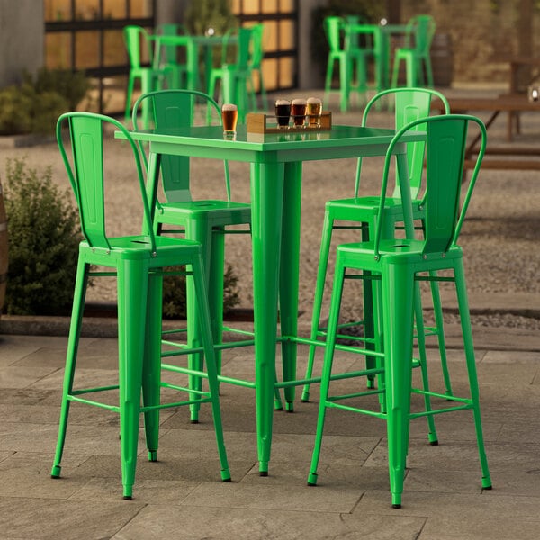 A Lancaster Table & Seating jade green bar height table with four green stools.
