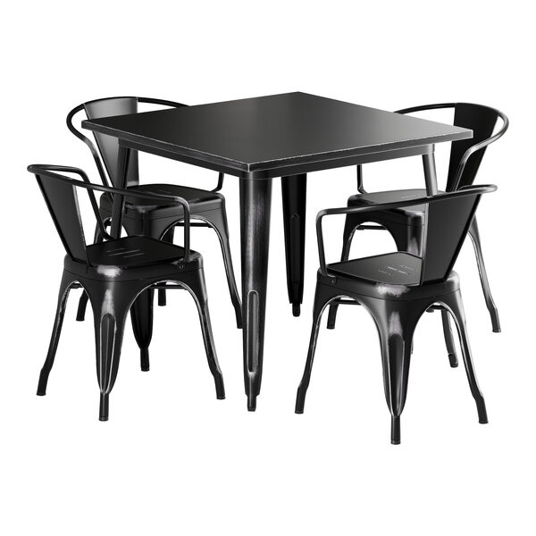 A Lancaster Table & Seating distressed onyx black metal table with four chairs.