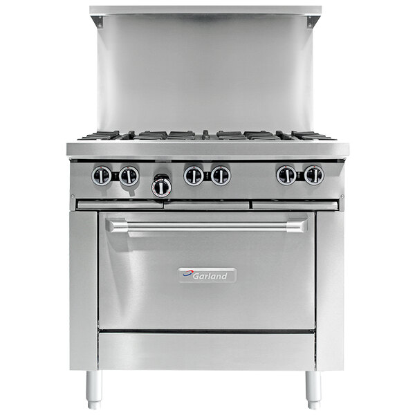 A stainless steel Garland commercial gas range with a griddle and storage base.