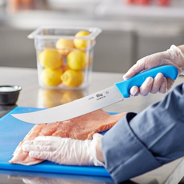 A person cutting a piece of meat with a Choice cimeter knife with a blue handle.