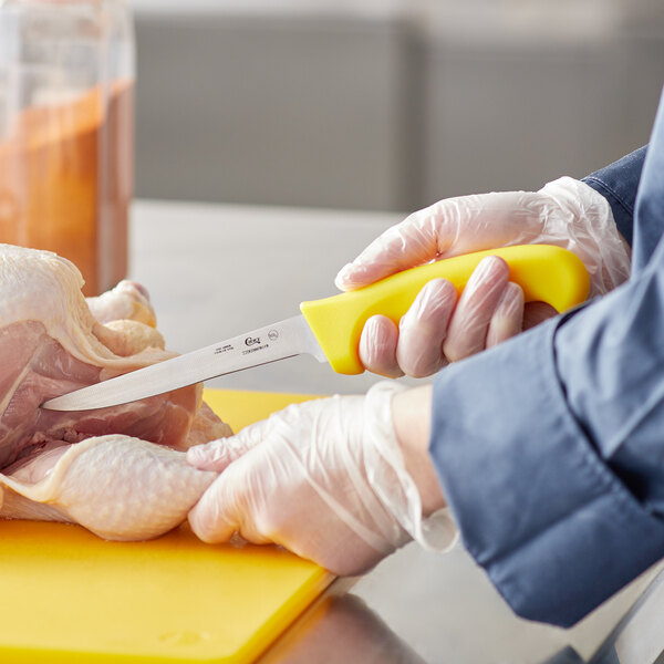 a person cutting a chicken