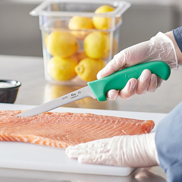 A person using a Choice narrow stiff boning knife to cut fish.