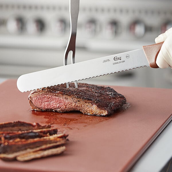 A person using a Choice bread knife to cut a piece of meat on a cutting board.
