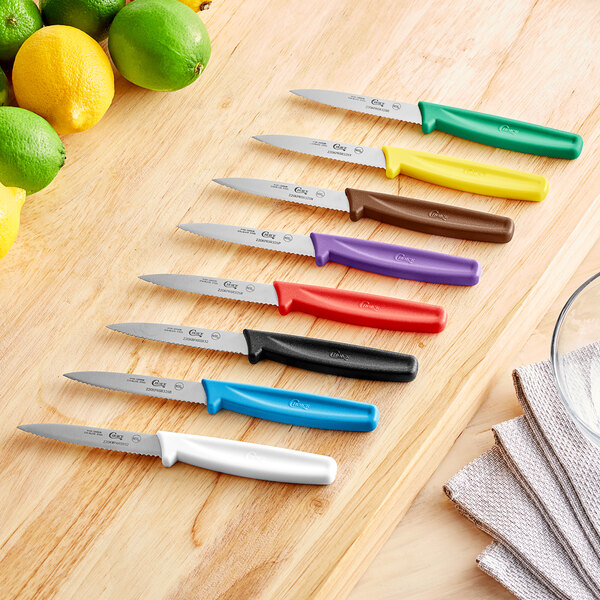 A Choice paring knife set with different colored handles on a wooden surface.