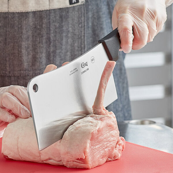 Cleaver being used to cut through pork