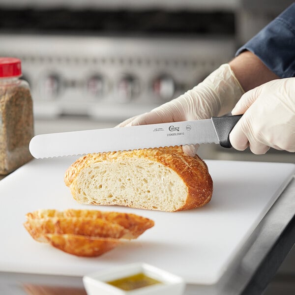 Bread knife being used to slice through a loaf of bread