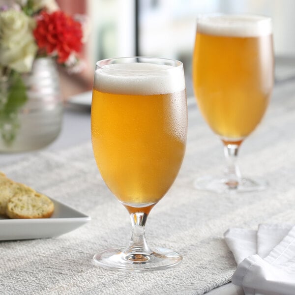 Two Nude Reserva stemmed beer glasses on a table.