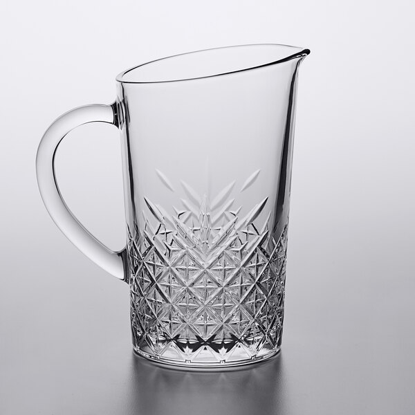 A Pasabahce clear glass pitcher with a handle.