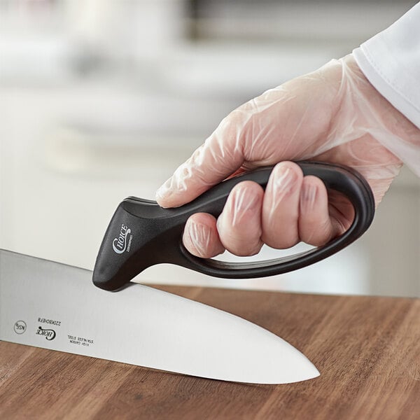 Person sharpening a knife with a handheld knife sharpener