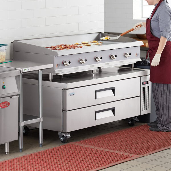 A woman using a Cooking Performance Group countertop gas griddle to cook food.