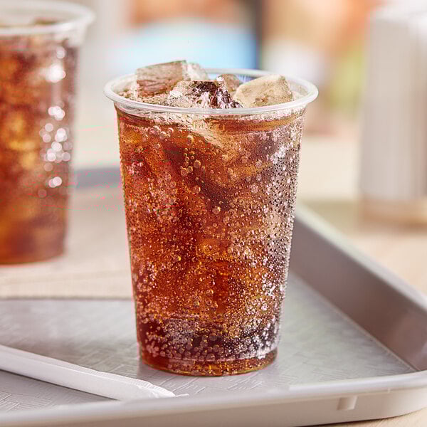Two EcoChoice PLA compostable plastic cups filled with soda on a tray.