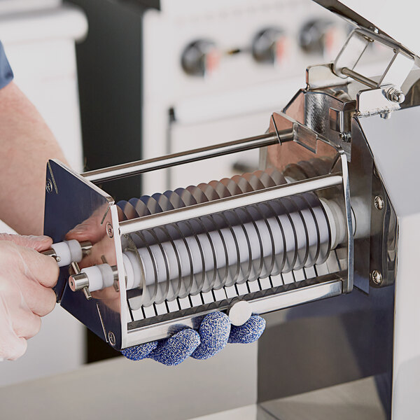 A person operating an Avantco Meat Stripper Blade Set on a machine.