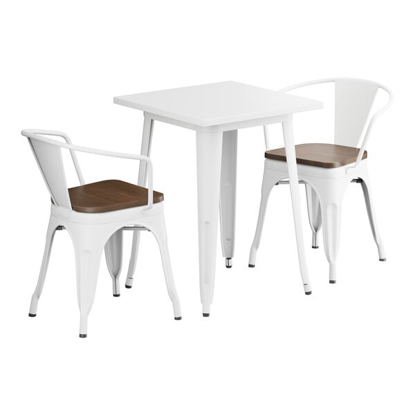 A white Lancaster Table & Seating table with two chairs with walnut wood seats.