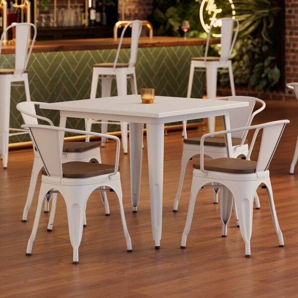 A Lancaster Table & Seating white table with walnut wood chairs.