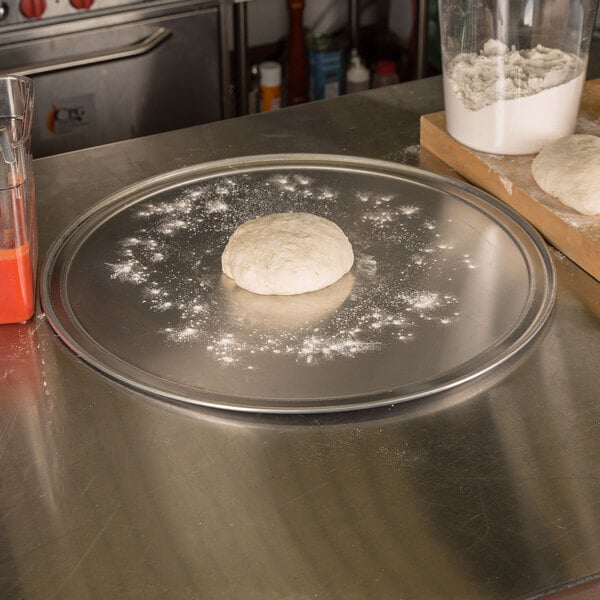 A dough ball on an American Metalcraft aluminum pizza pan.