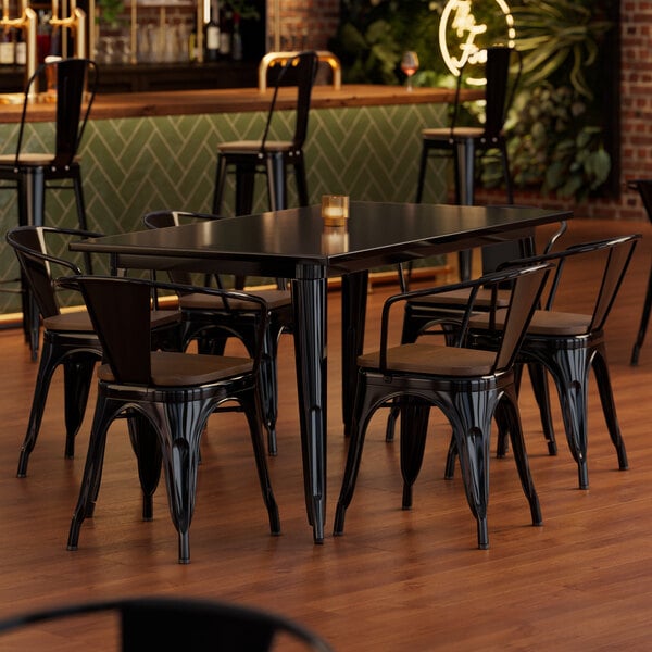 A Lancaster Table & Seating Onyx Black table with chairs with walnut seats.