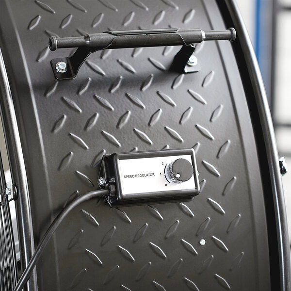 The black metal wheel and dial on a TPI fixed belt drive drum fan.