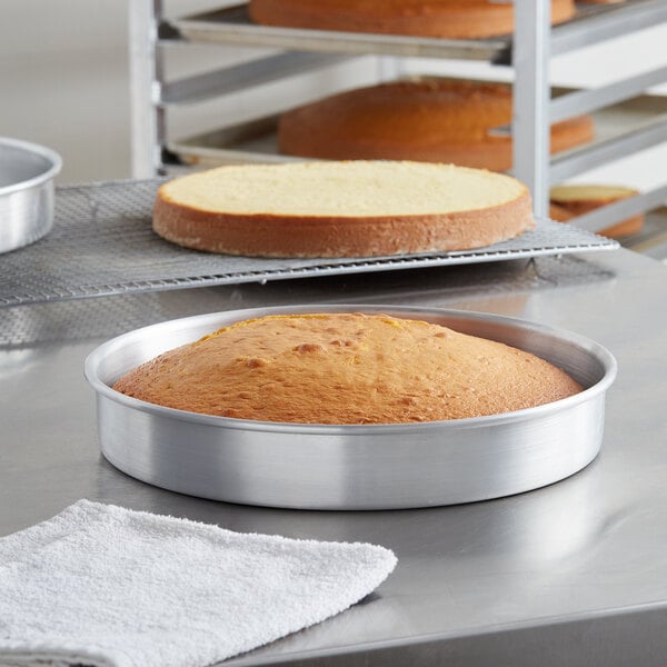 A cake in a Choice round aluminum cake pan on a counter.