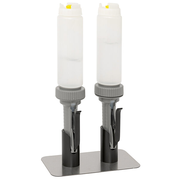 A Nemco countertop stand holding two hand sanitizer pumps above two plastic bottles.