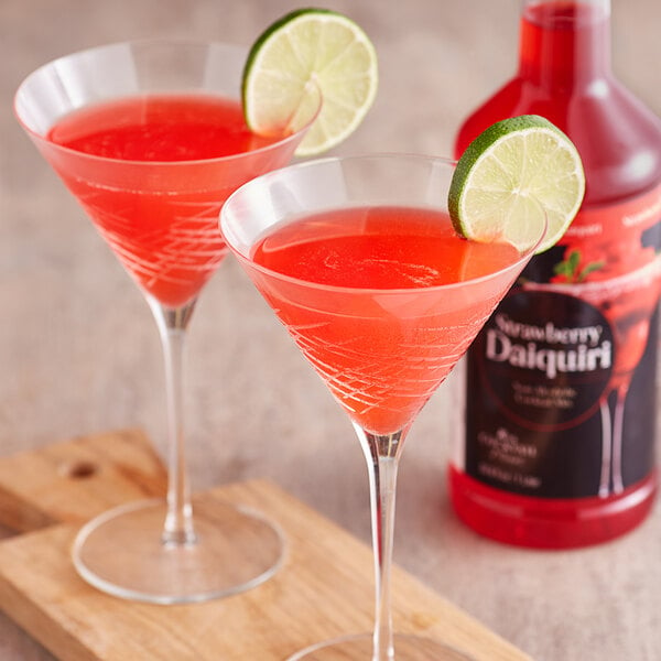 two strawberry daiquiris garnished with a lime wheel