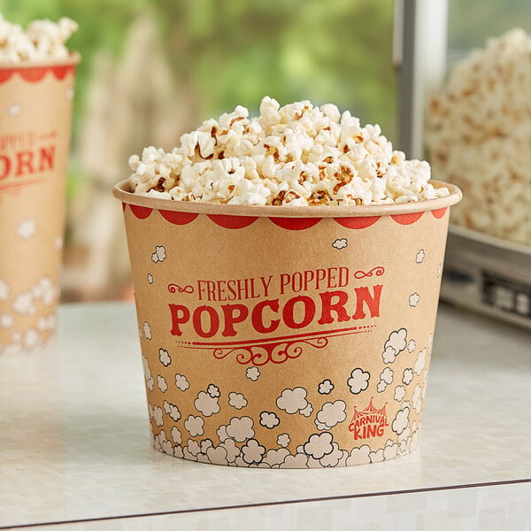 Two Carnival King Kraft popcorn buckets filled with popcorn on a table.