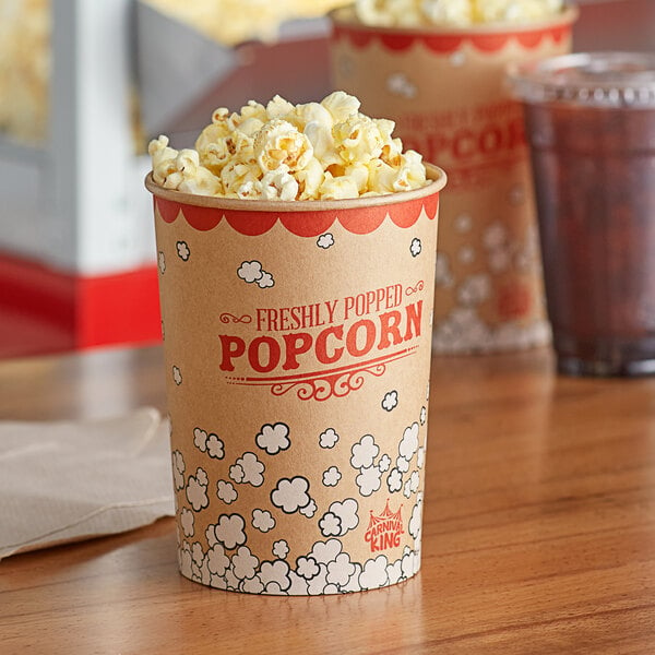 Two Carnival King paper cups filled with popcorn on a table.