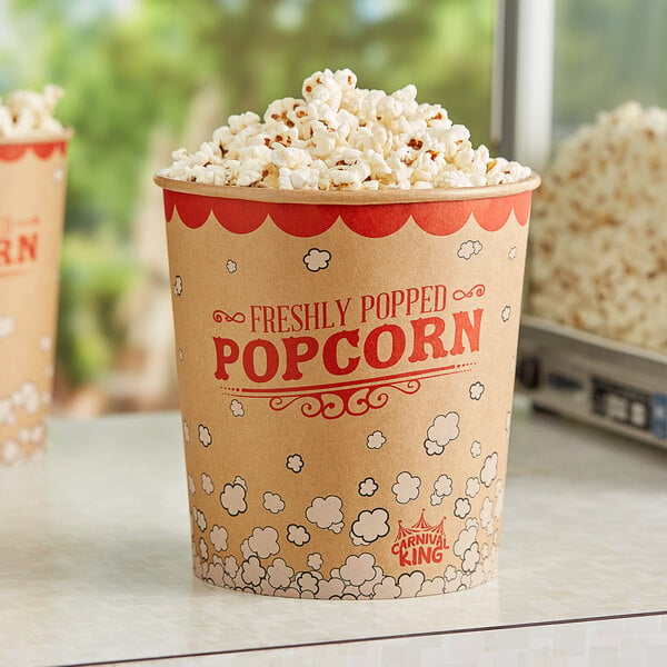 Two Carnival King popcorn buckets filled with popcorn on a table.