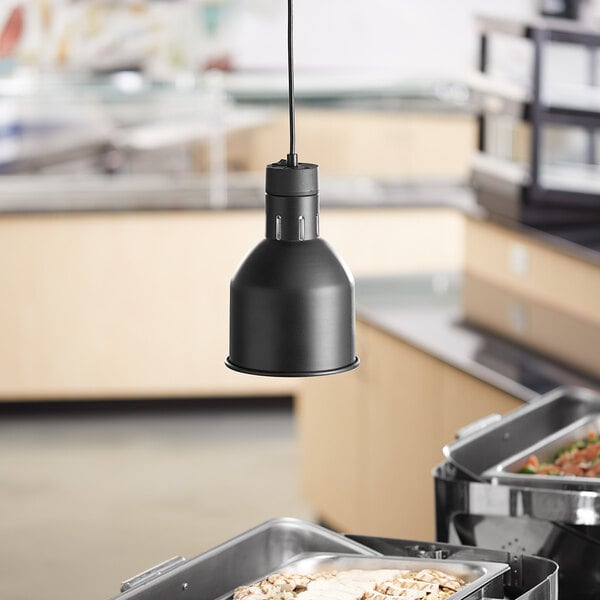 A ServIt black ceiling mount heat lamp with a flared round dome shade hanging over food on a buffet table.
