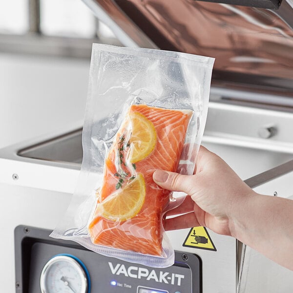 A person holding a vacuum packaged salmon bag.