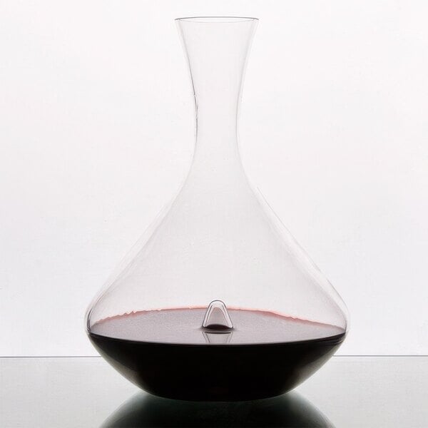 A Stolzle glass decanter with a red liquid inside.