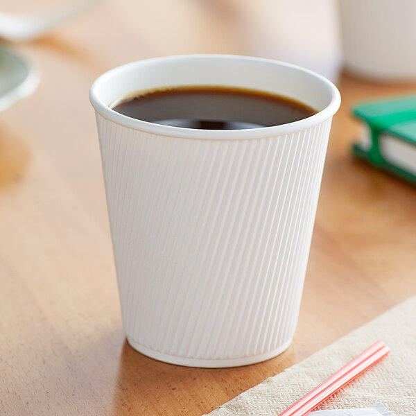 A Choice white double wall paper hot cup on a table.