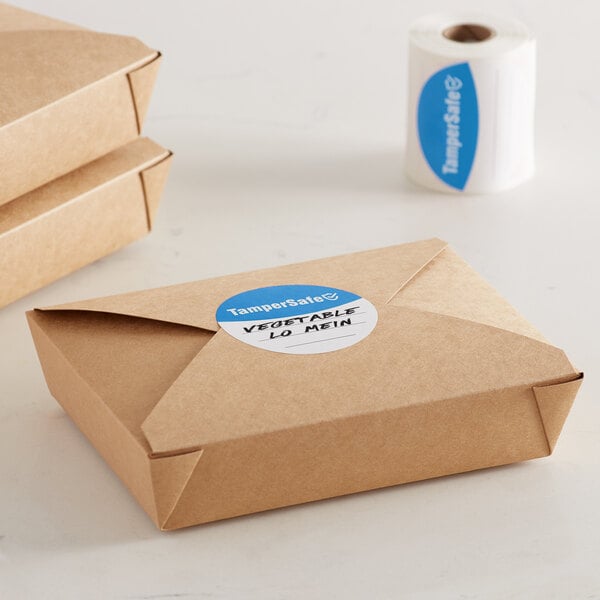 A brown box with a roll of blue TamperSafe labels on a table.