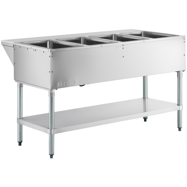 A ServIt stainless steel electric steam table with four sealed wells on a counter in a school kitchen.